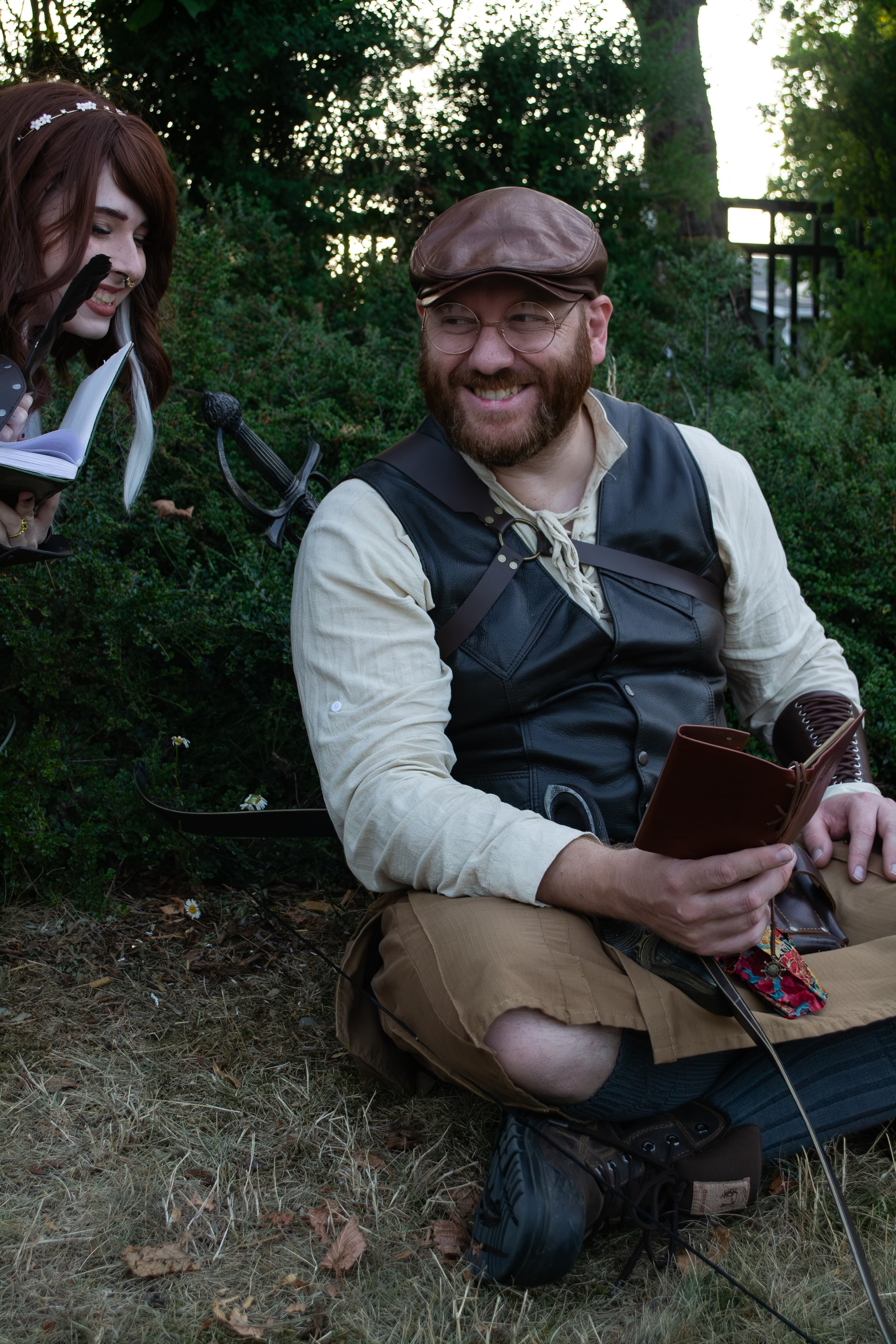 Two people wearing fantasy costumes smiling and laughing together.