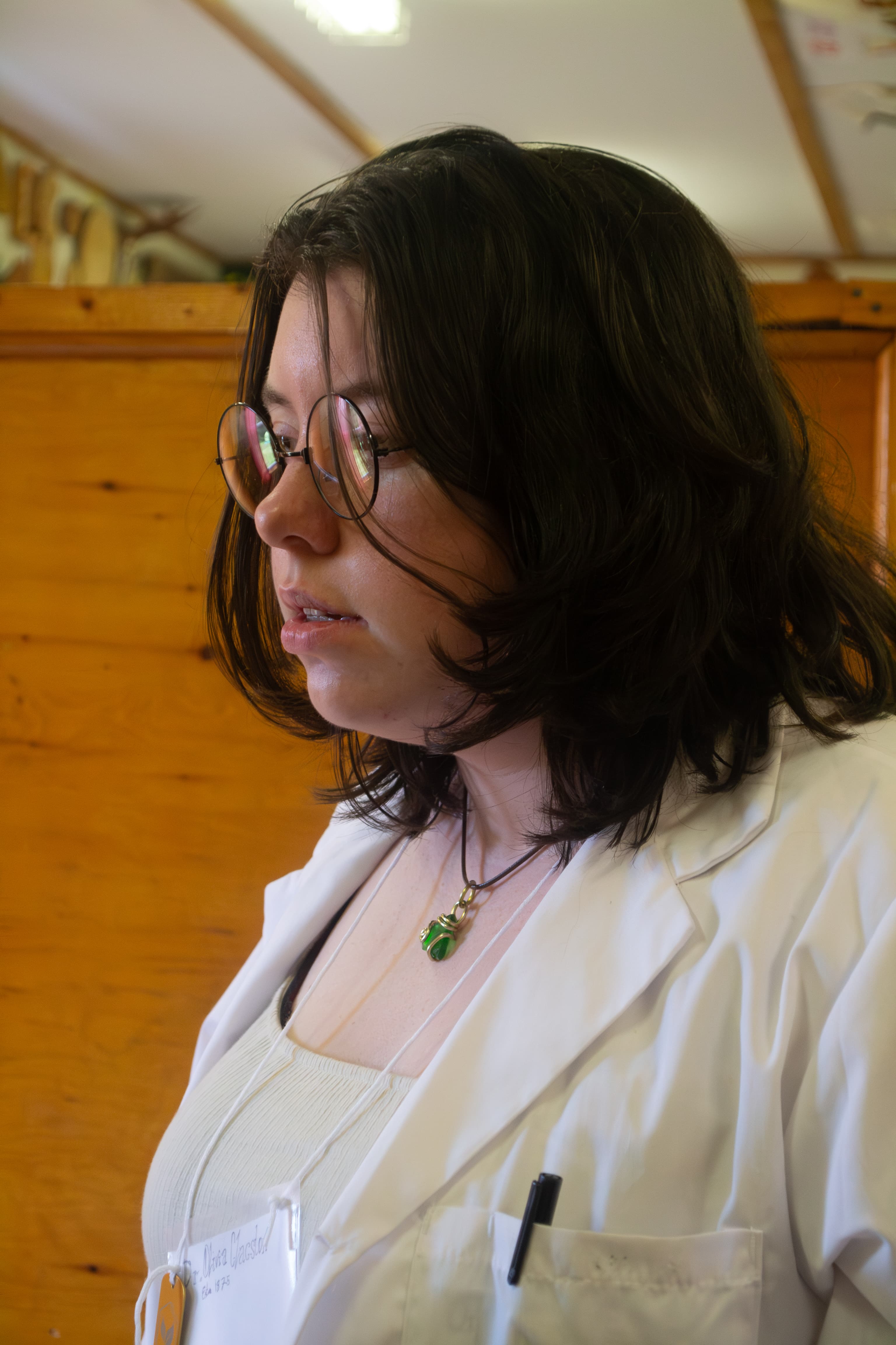 A person wearing a scientific researcher costume looks at something off-screen.