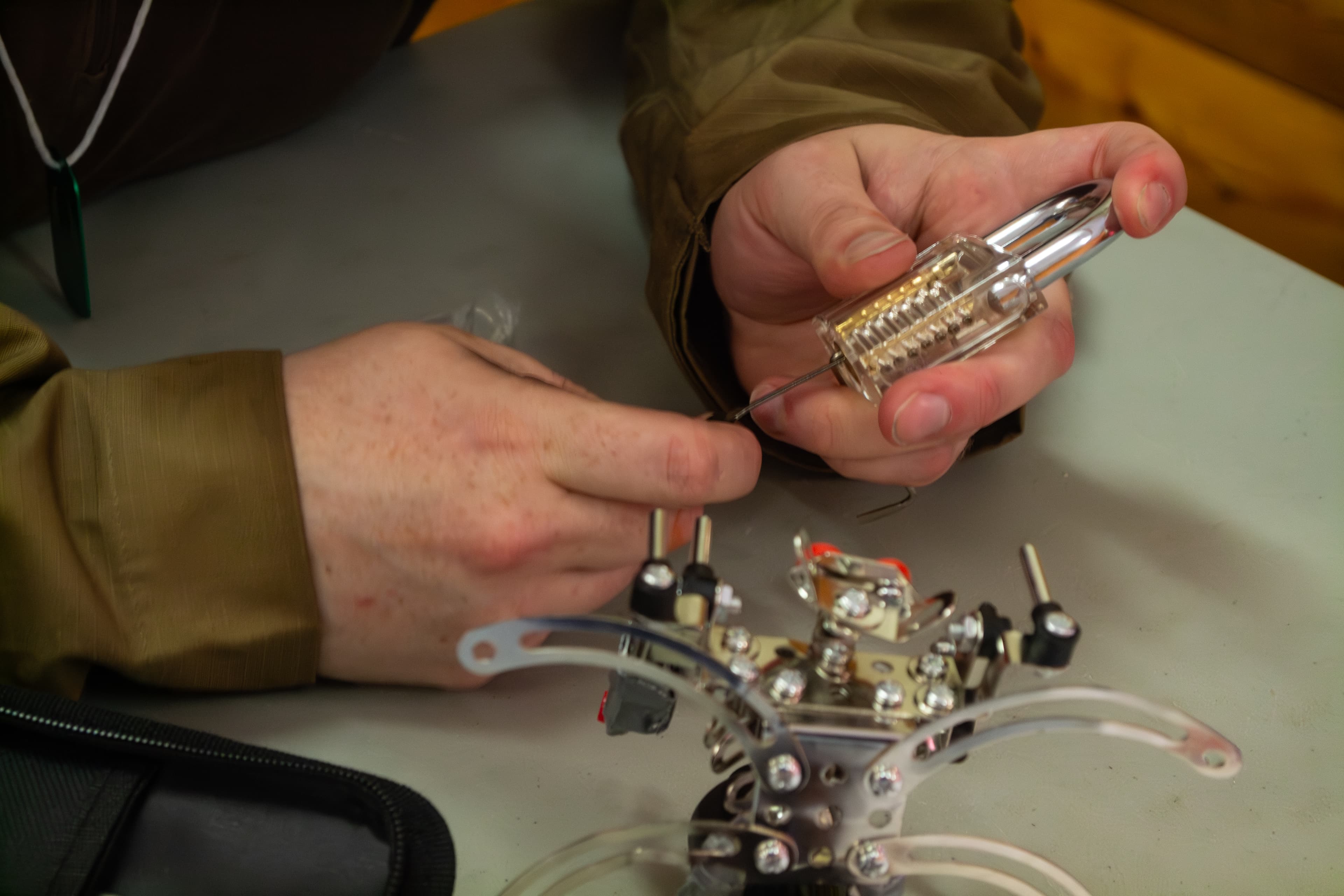 Two hands assembling a miniature robot.